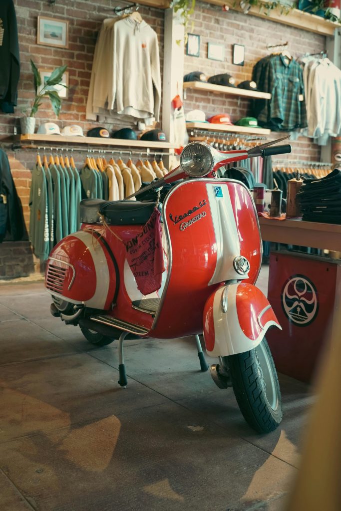 Scooter rétro rouge et blanc photographié en boutique avec une focale standard mettant en valeur les détails et la perspective naturelle